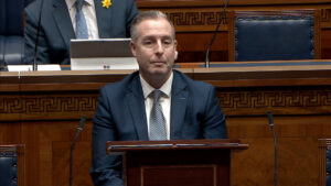 The Minister for Education sitting in the Assembly Chamber