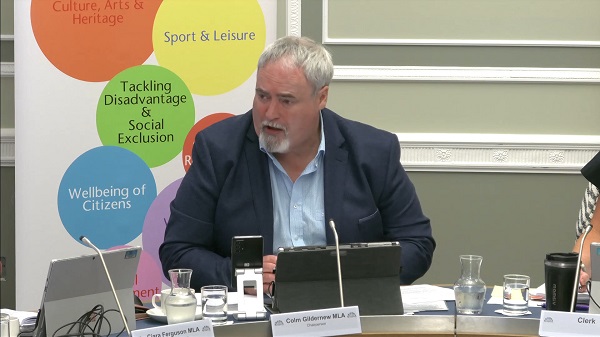 Colm Gildernew, Chair of the Communities Committee sitting in a committee room in Parliament Buildings