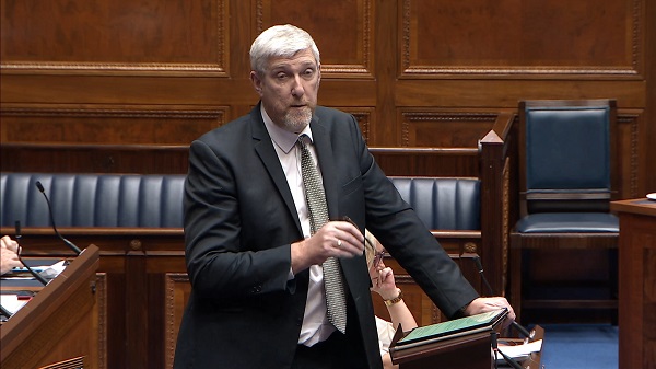 Infrastructure Minister John O'Dowd standing in the Assembly Chamber