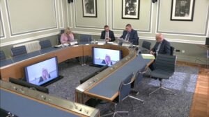 Members of the Audit Committee sitting in a committee room in Parliament Buildings