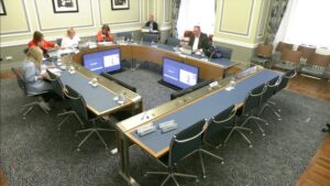 Members of the Committee on Procedures sitting in a committee room in Parliament Buildings