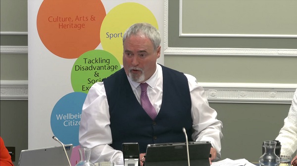 Colm Gildernew, Chair of the Communities Committee sitting in a committee room in Parliament Buildings
