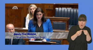 Deputy First Minister, Emma Little-Pengelly, answers Members questions in the Assembly Chamber on Monday 10 june 2024. In the foreground there is an ISL interpreter who is interpreting Ms Little-Pengelly's answers.