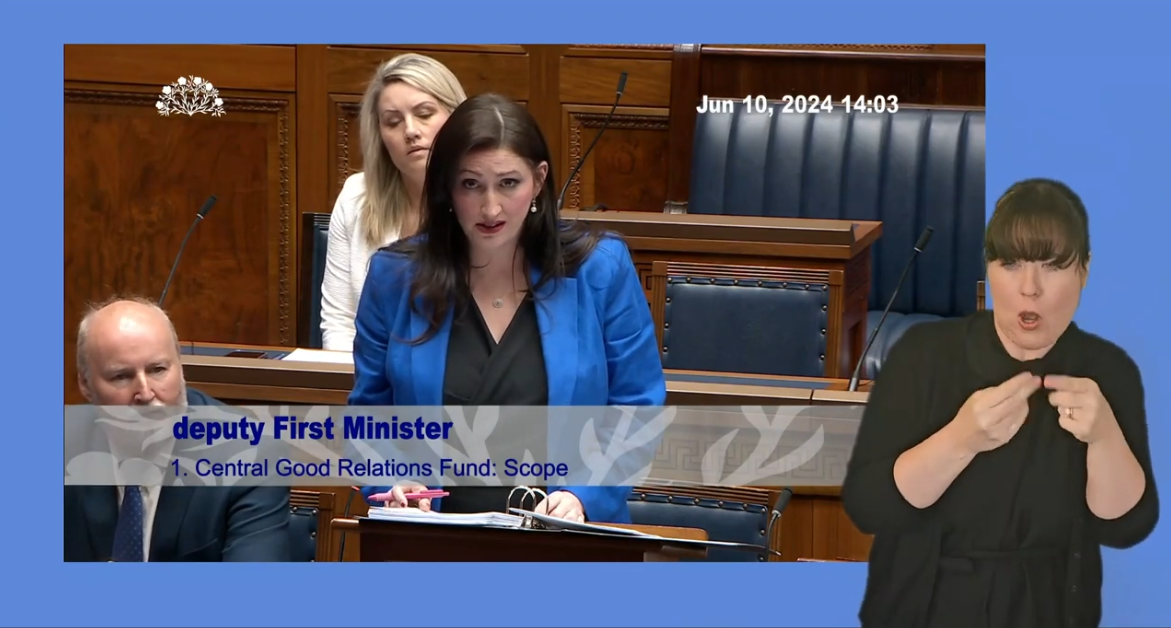 Deputy First Minister, Emma Little-Pengelly, answers Members questions in the Assembly Chamber on Monday 10 june 2024. In the foreground there is an ISL interpreter who is interpreting Ms Little-Pengelly's answers.