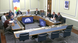 Members of the Infrastructure Committee sitting in a committee room in Parliament Buildings