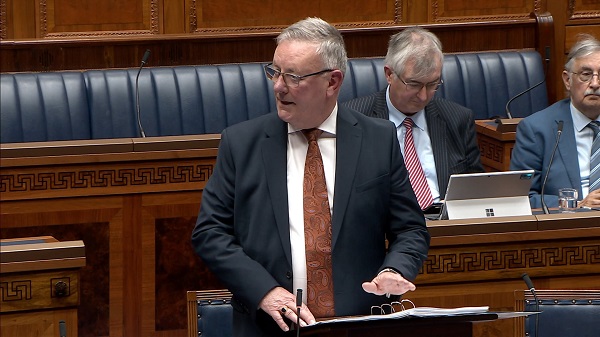 Health Minister Mike Nesbitt standing in the Assembly Chamber
