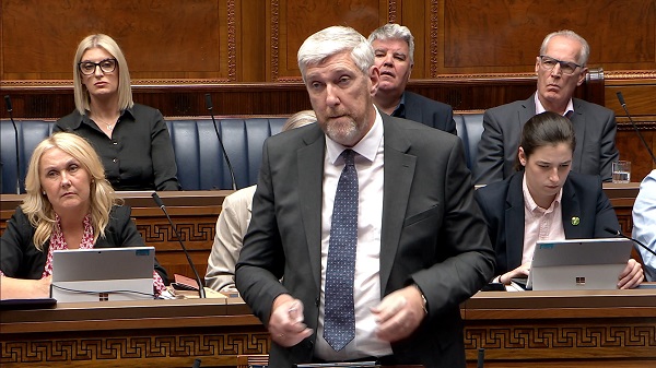Infrastructure Minister John O'Dowd standing in the Assembly Chamber