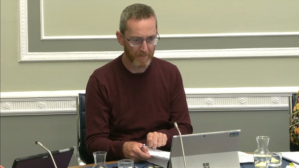 Committee Chair Philip McGuigan sitting in a committee room in Parliament Buildings