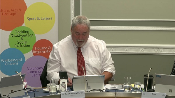 Colm Gildernew, Chair of the Communities Committee sitting in a committee room in Parliament Buildings