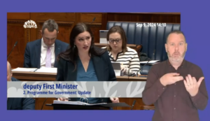Deputy First Minister, Emma Little-Pengelly, answering Members questions in the Assembly Chamber during Question Time on Monday 9 September 2024. In the foreground is an Irish Sign Language interpreter interpreting the questions and answers.