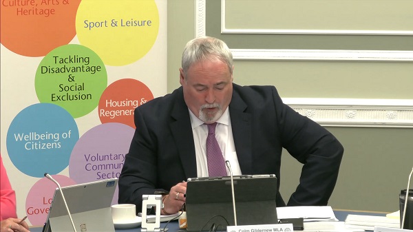 Colm Gildernew, Chair of the Communities Committee sitting in a committee room in Parliament Buildings