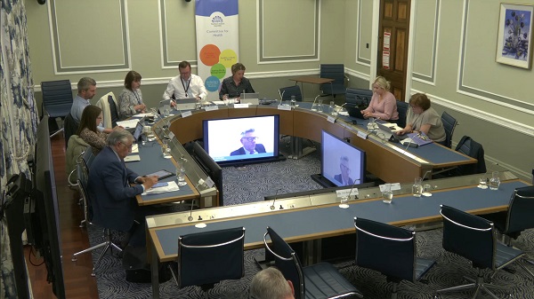 Members of the Health Committee sitting in a committee room in Parliament Buildings