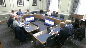 Members of the Public Accounts Committee sitting in a committee room in Parliament Buildings.