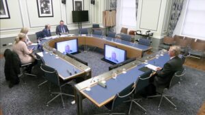 Members of the Audit Committee sitting in a committee room in Parliament Buildings