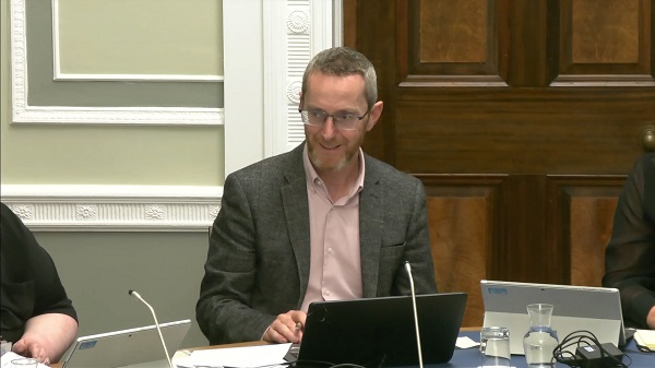 Committee Chair Philip McGuigan sitting in a committee room in Parliament Buildings