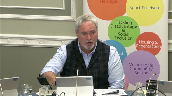 Colm Gildernew, Chair of the Communities Committee sitting in a committee room in Parliament Buildings