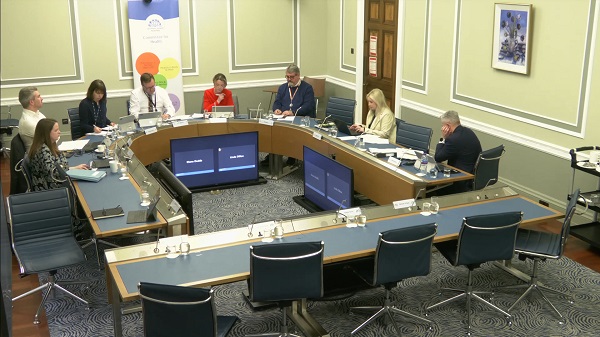 Members of the Committee sitting in a committee room in Parliament Buildings.