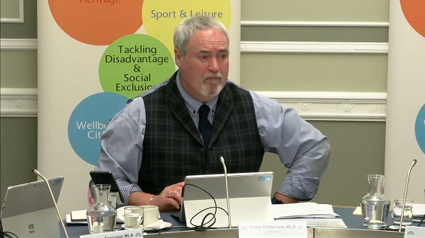 Colm Gildernew, Chair of the Communities Committee sitting in a committee room in Parliament Buildings