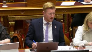 Chair of the Public Accounts Committee Daniel McCrossan sitting in a the Senate Chamber of Parliament Buildings