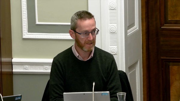 Committee Chair Philip McGuigan sitting in a committee room in Parliament Buildings