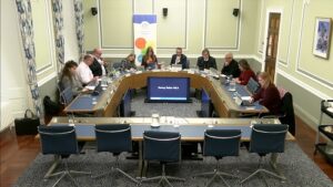 Members of the Committee sitting in a committee room in Parliament Buildings.
