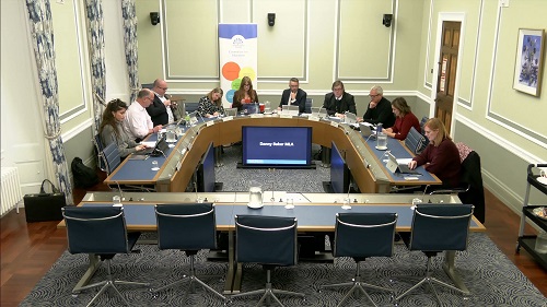 Members of the Committee sitting in a committee room in Parliament Buildings.